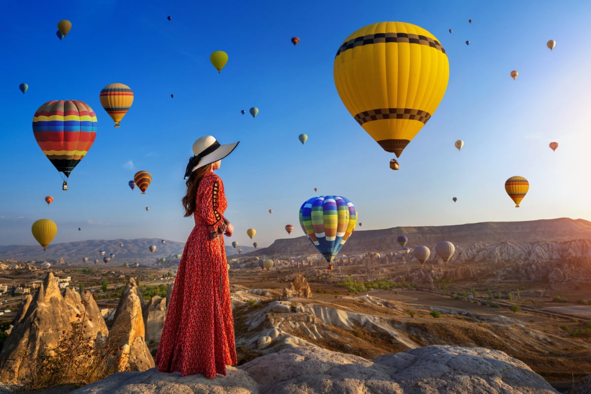 woman standing and looking to hot air balloons in Cappadocia, Turkey